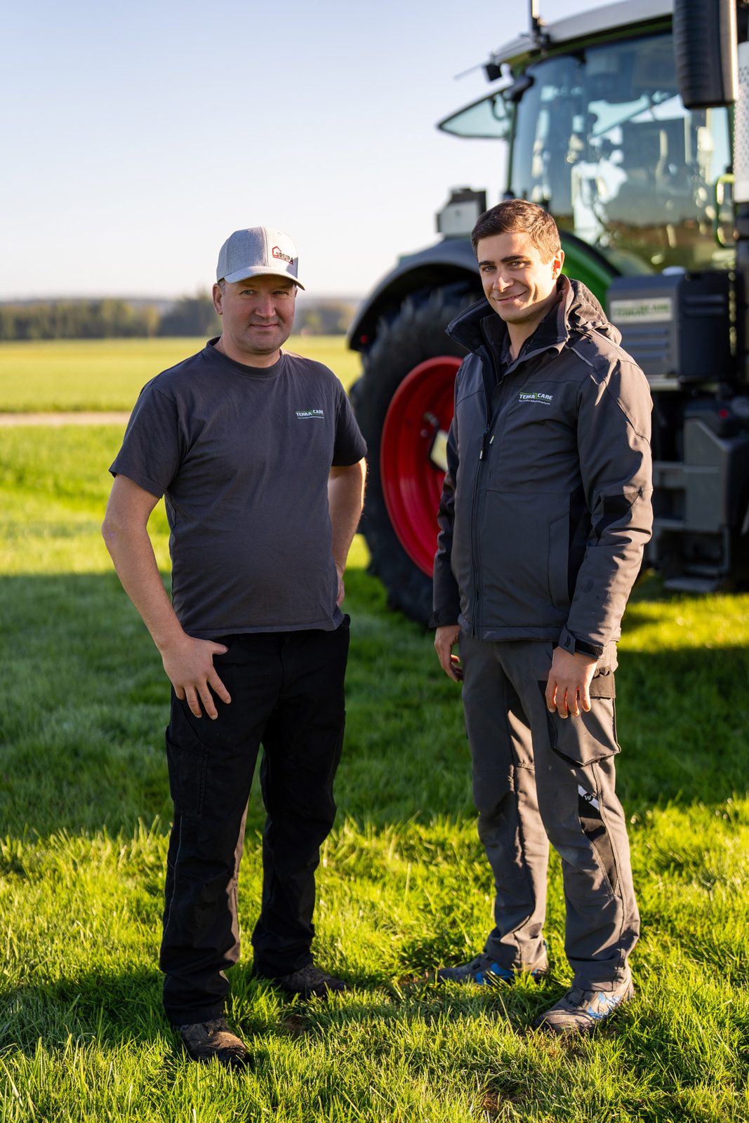 Zwei Männer vor einem Traktor auf der Wiese – TerraCare-Partnernetzwerk